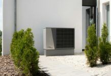 Aerotermia: cuánto consume, cuánto puede ahorrar y cuándo compensa en 2026 Unidad exterior de una bomba de calor aire-agua instalada junto a una vivienda